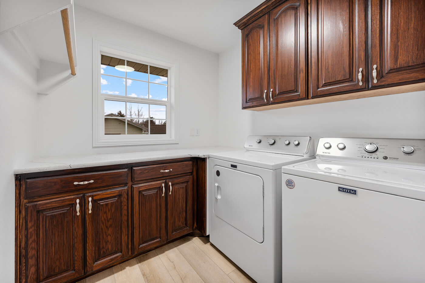 Laundry room with dark wood cabinetry and natural light