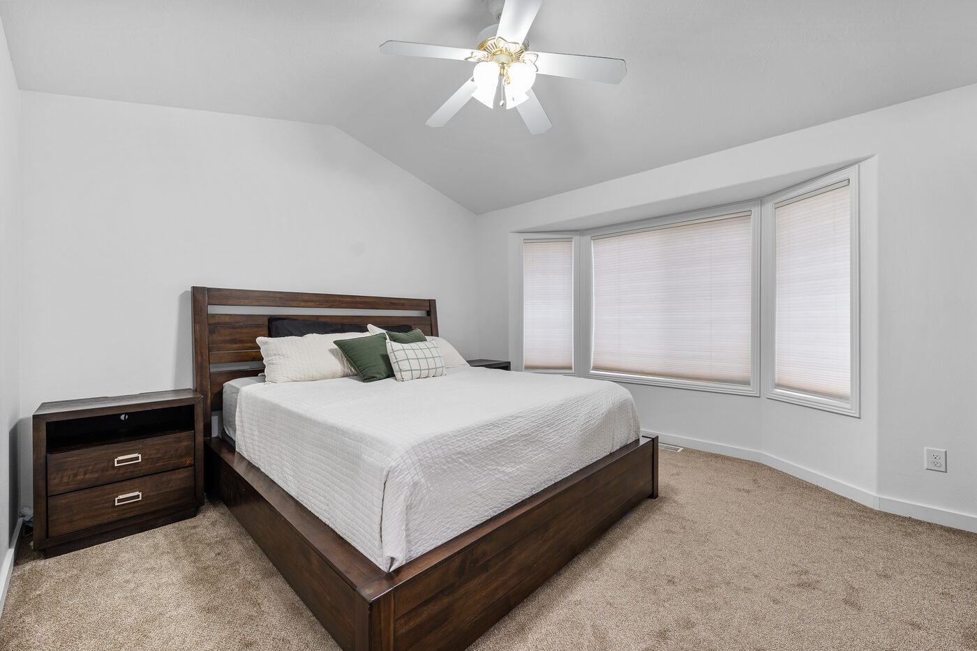 Main floor master bedroom with vaulted ceiling, ceiling fan, and bay window at 625 Vale Lane